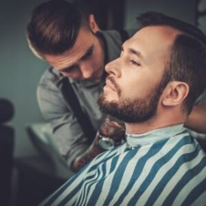 confident-man-visiting-hairstylist-in-barber-shop-PR3JT7K.jpg