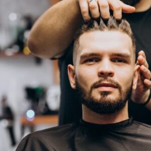 Hairdresser at a barber shop styling hair of a client